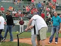 Coach Smith helping Samuel bat.